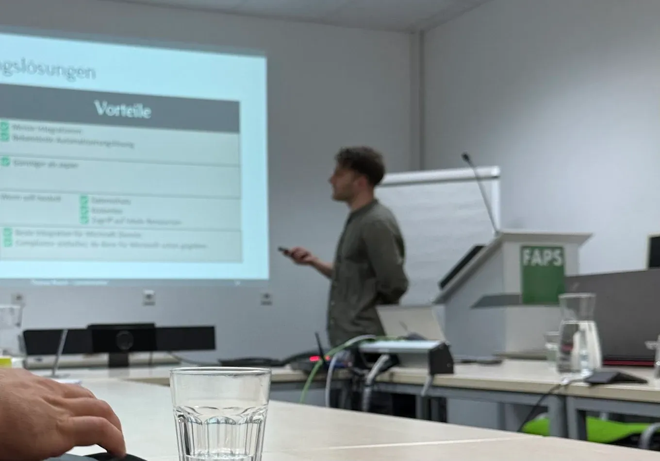 Thomas Rauch beim Vortrag am FAPS-Lehrstuhl mit Folie zu Vorteilen von KI-Lösungen